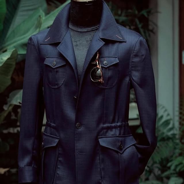 Giacca sahariana blu navy su manichino, tra le piante del cortile